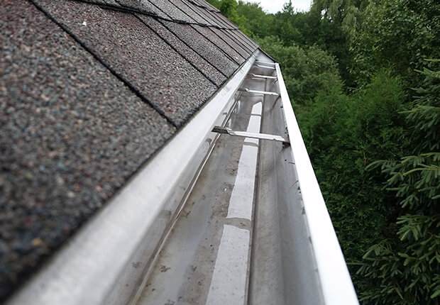 Blocked gutter cleaning preventing water overflow and property damage