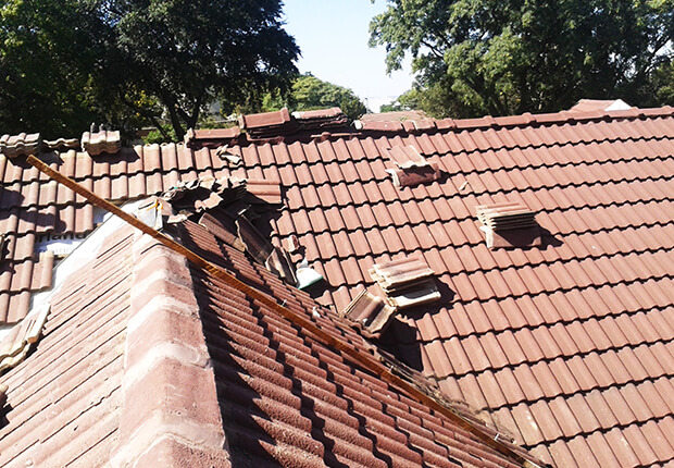 Damaged roof tiles being repaired by experienced roofing contractors